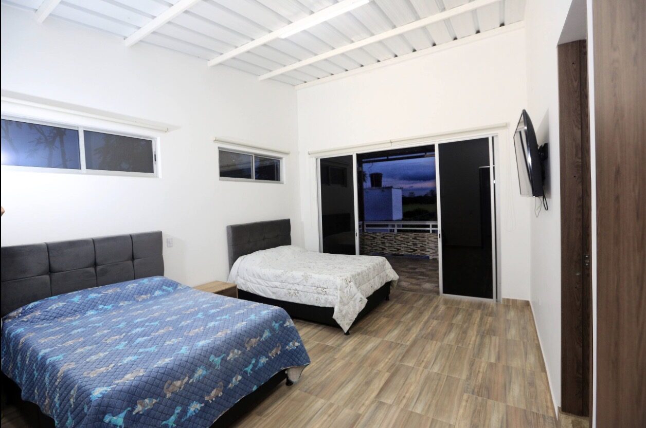 Habitación de Finca Mana con dos camas y televisor
